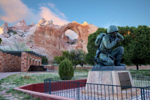 Photo of the Navajo Code Talker Monument in Window Rock, Arizona, with the Window Rock in the background.