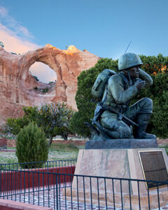 Photo of the Navajo Code Talker Monument in Window Rock, Arizona, with the Window Rock in the background.